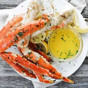 cooked king crab legs with melted butter and lemon wedges