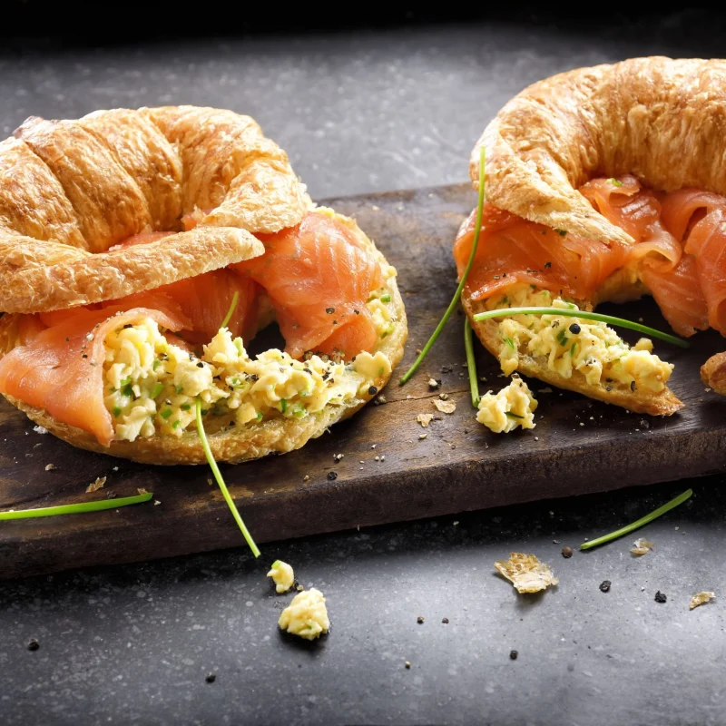 Fresh croissants with scrambled eggs and salmon